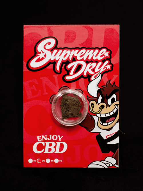 Supreme Dry CBD en polvo, producto en paquete con logo y personaje de caricatura.